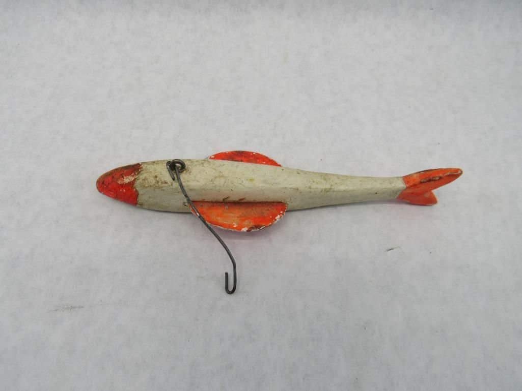 Fishing lure shaped like a fish, white body with orange head, fins, and tail; hook attached.