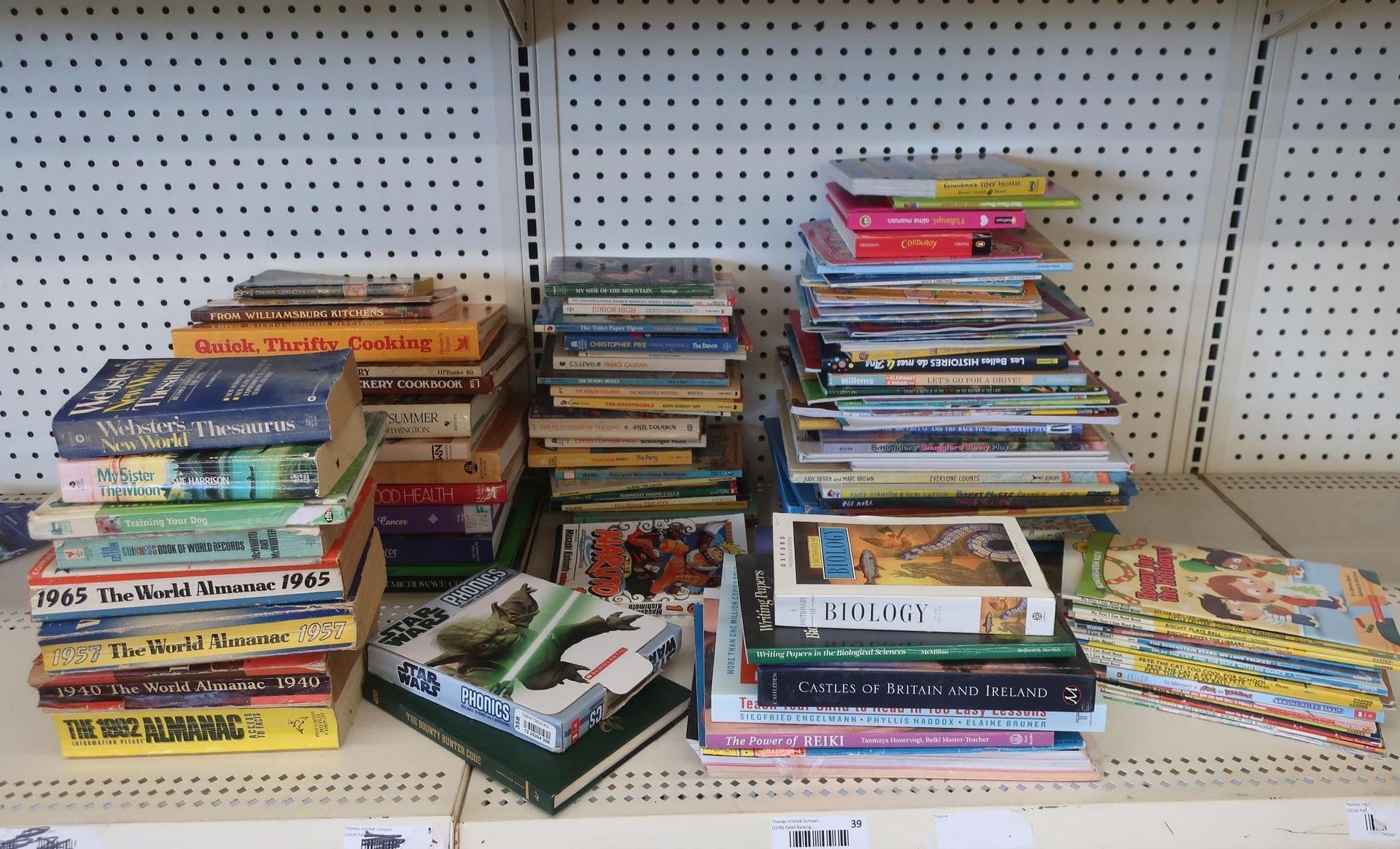 Books stacked on a shelf, varying sizes and colors. A Star Wars book is in front.
