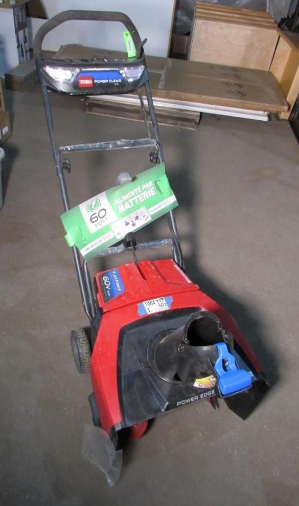 Red and black Toro snowblower with a green battery attached.
