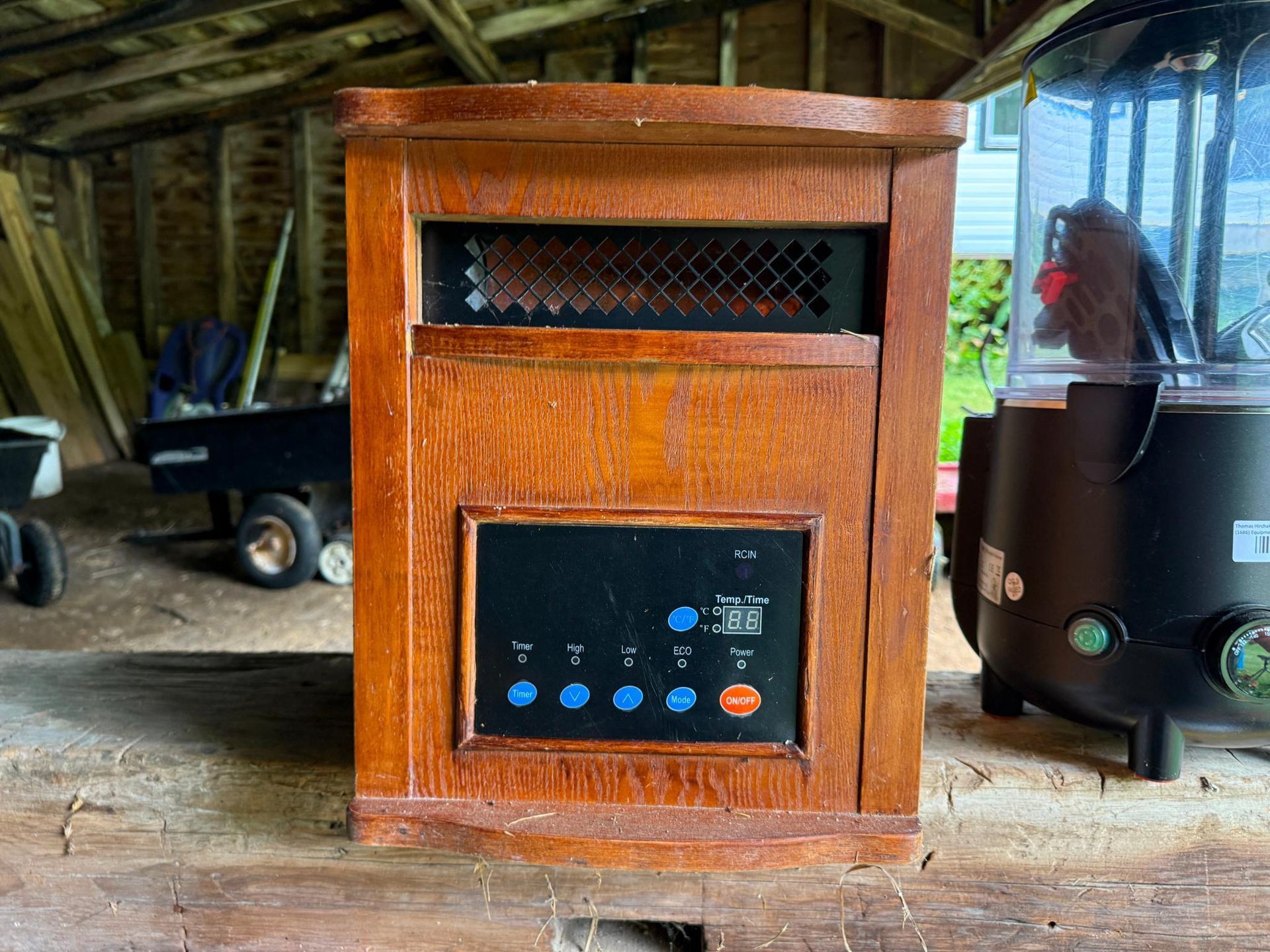 Wooden space heater with control panel, inside a shed.