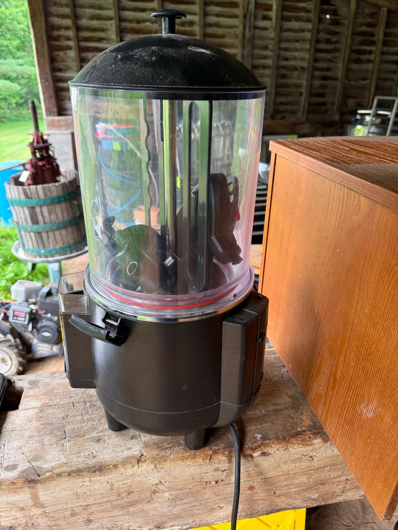 Black cylindrical appliance with a clear container.