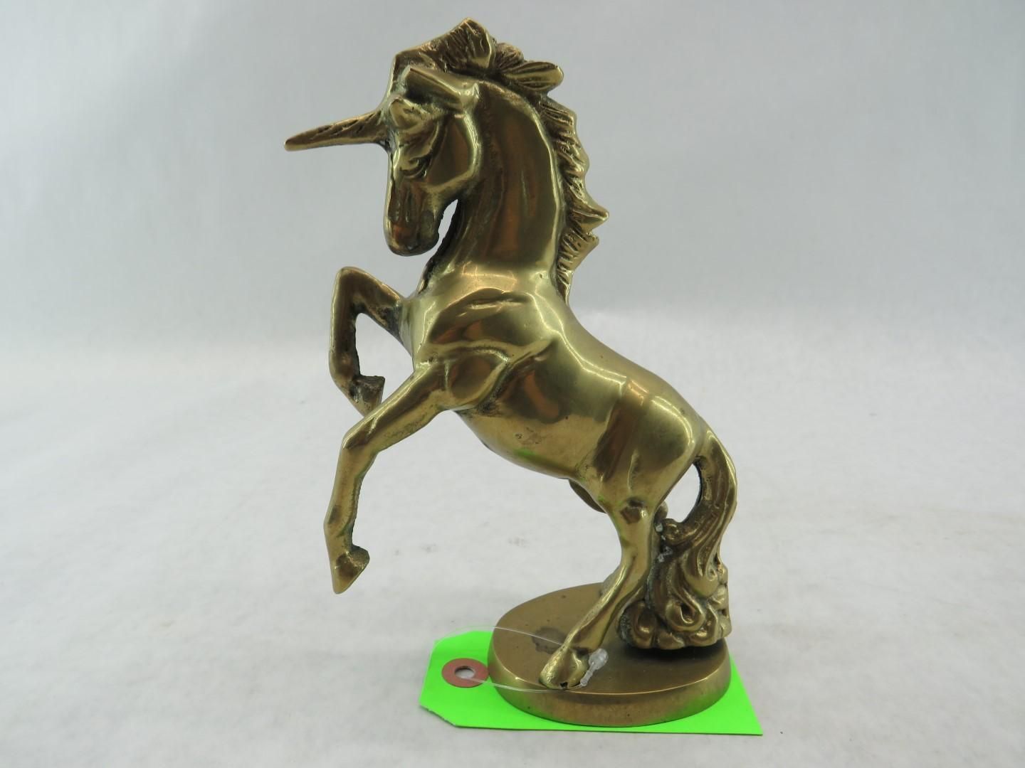 Brass unicorn statue rearing up on its hind legs.