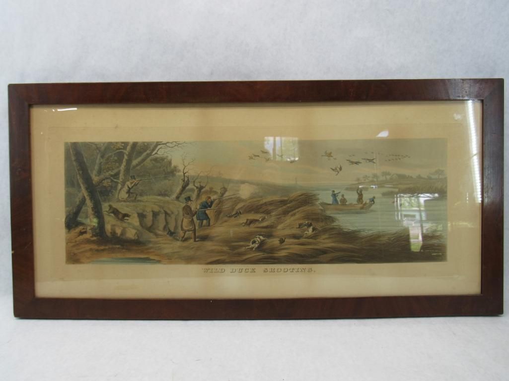 A framed print depicts duck hunters on a shore with a body of water and ducks in flight.