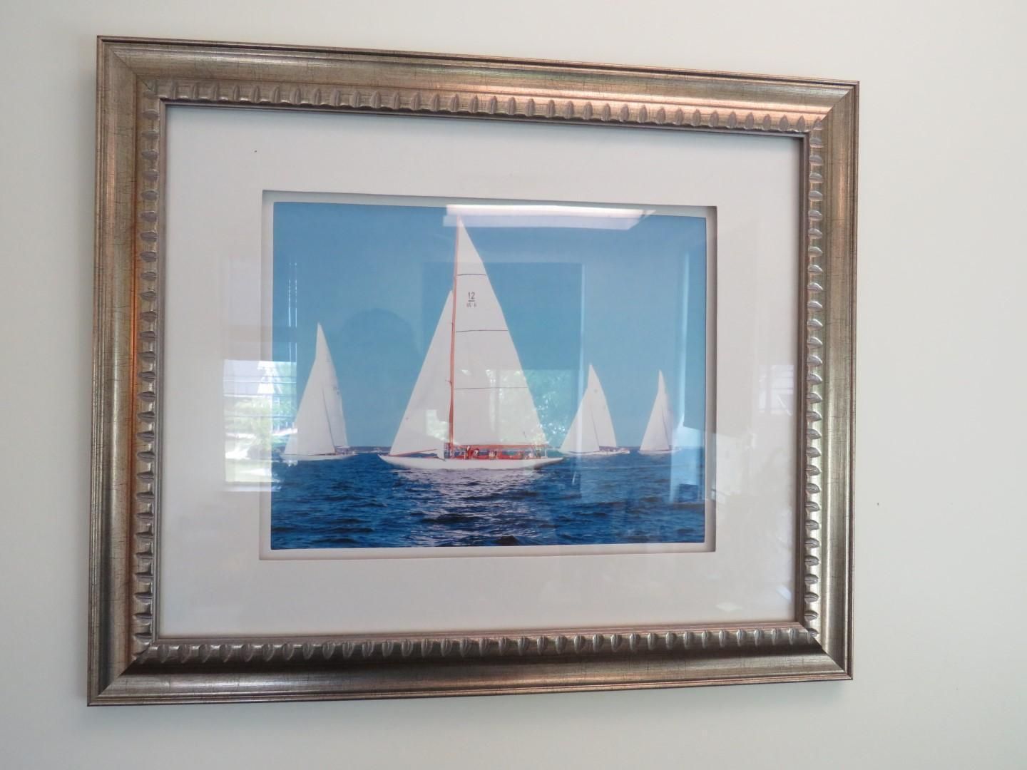 Sailboats on blue water, framed print on white wall, silver border.