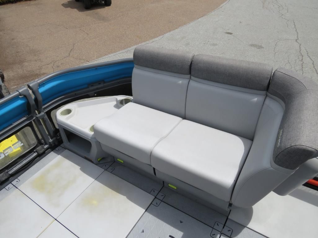 A gray and white boat bench with a built-in table and cup holders. The bench has a gray backrest.