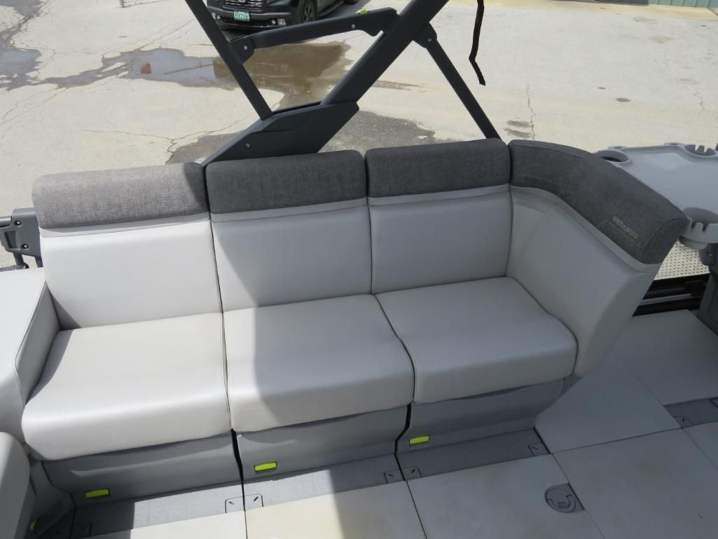 Boat seating with gray and white cushions. Black frame overhead.