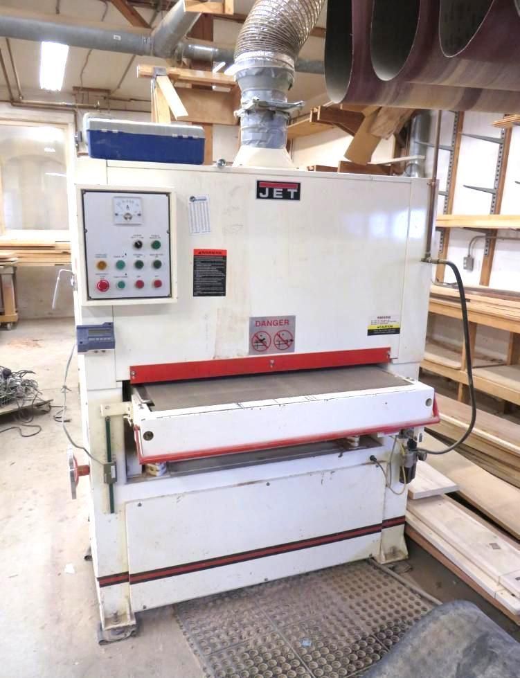 Large white Jet sander machine in a workshop setting with control panel and dust collection system.