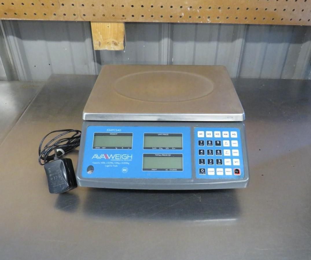 Digital retail scale with blue display, keypad, and power adapter.