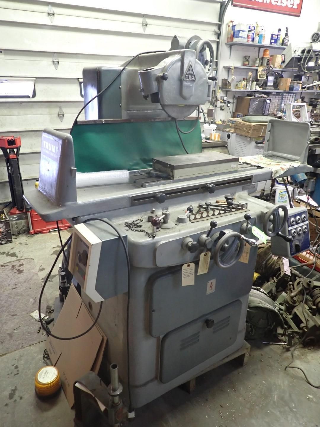 Gray industrial surface grinder in a workshop setting.