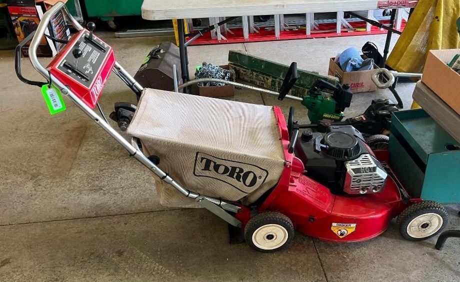 Red Toro lawnmower with a white bag.