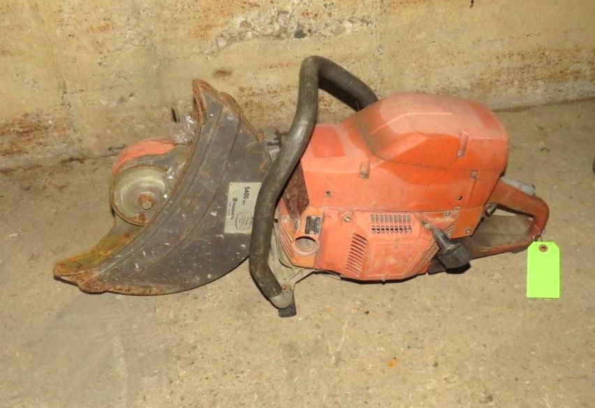 Orange Husqvarna concrete saw on a concrete surface.