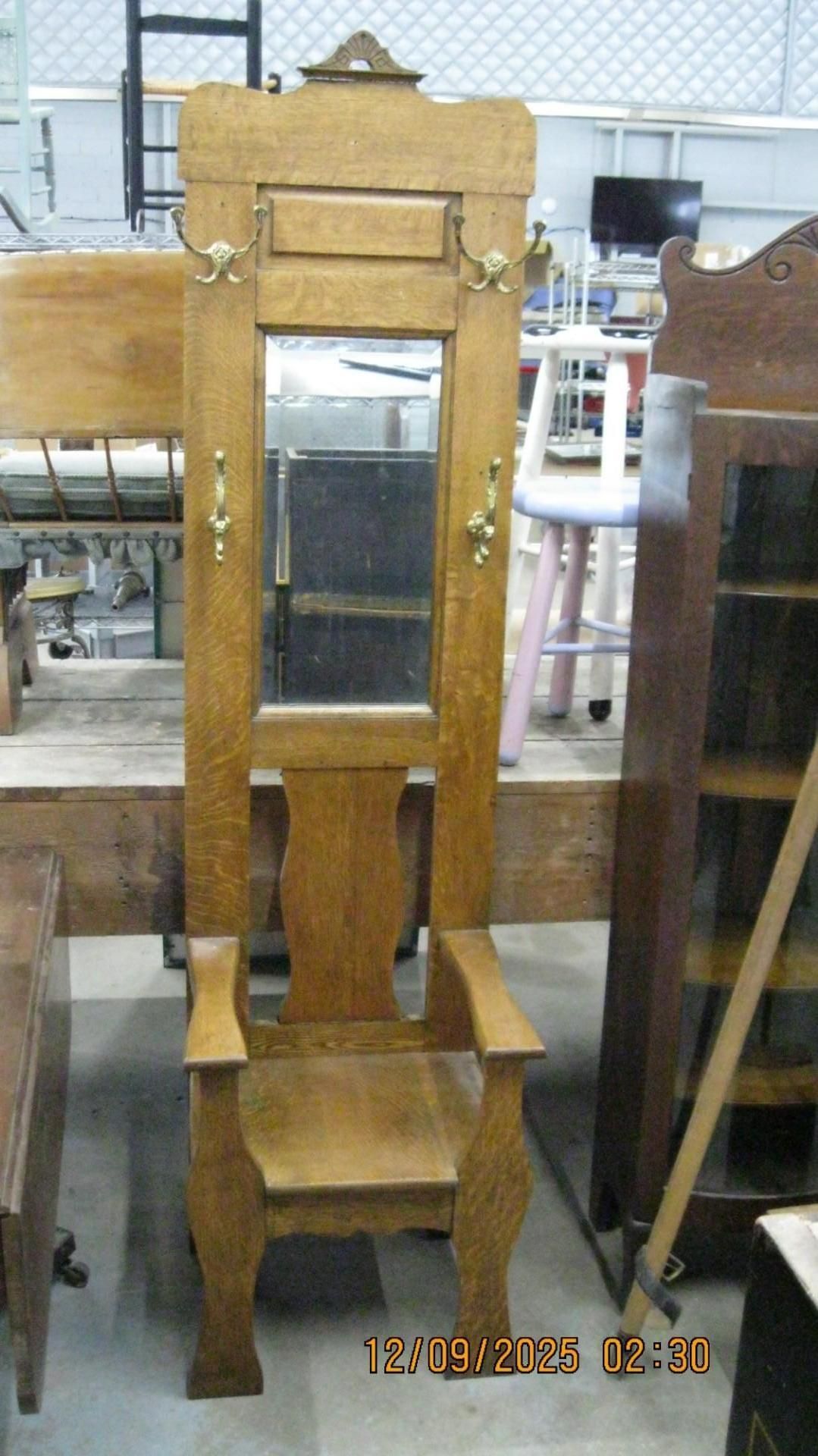 Wooden hall tree with a mirror, coat hooks, and chair.
