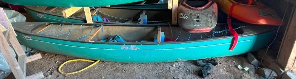 Green canoe  with safety vests and another kayak visible.