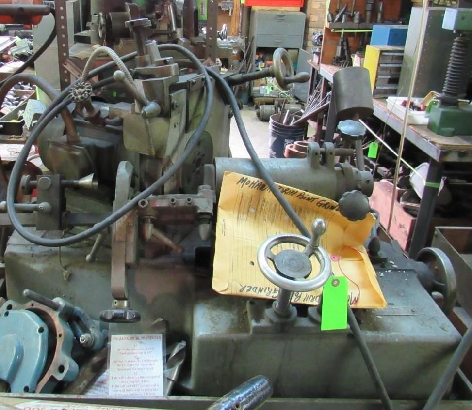 Industrial machine with various levers, dials, and a paper note attached. Gray metal.