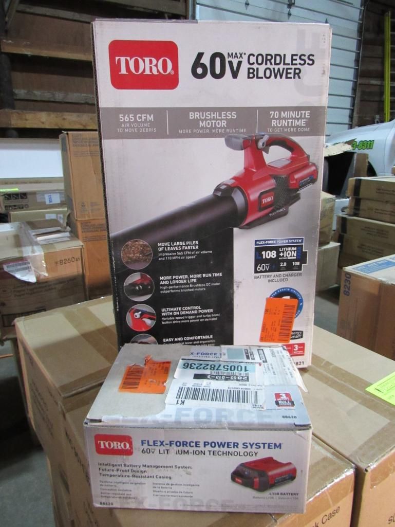 Toro 60V cordless blower box with battery charger box on top of boxes in a warehouse.