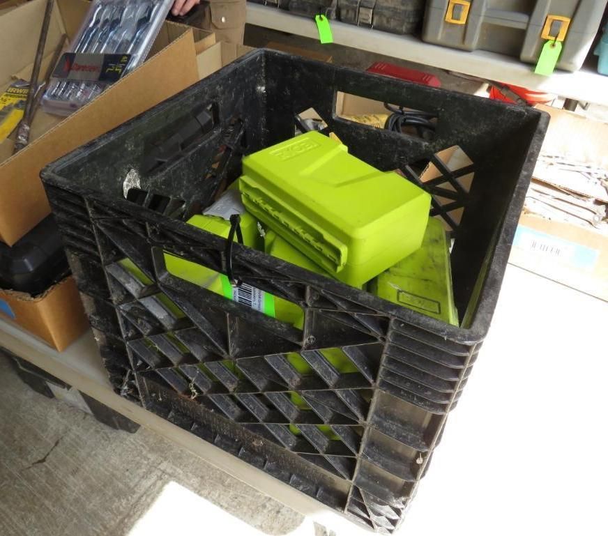Black crate filled with green power tool batteries.