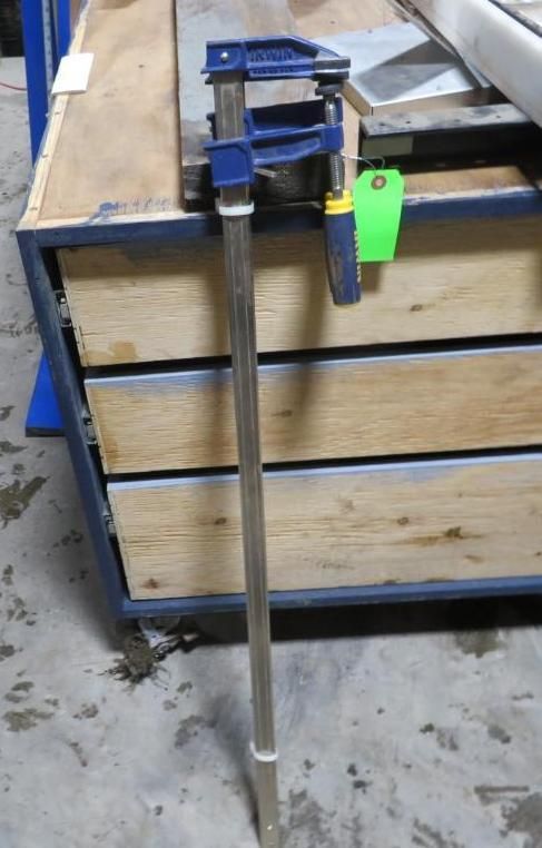 Bar clamp. Blue and silver clamp with a green tag.