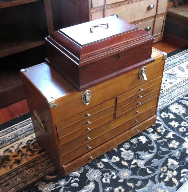 Two wooden boxes stacked on each other; a smaller box on top, atop a larger chest of drawers.
