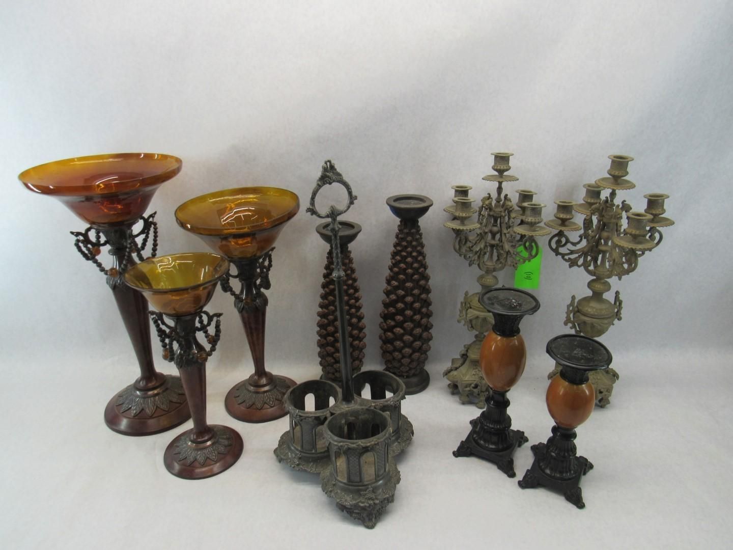 Various decorative vases, candle holders, and candelabras in bronze and amber colors.