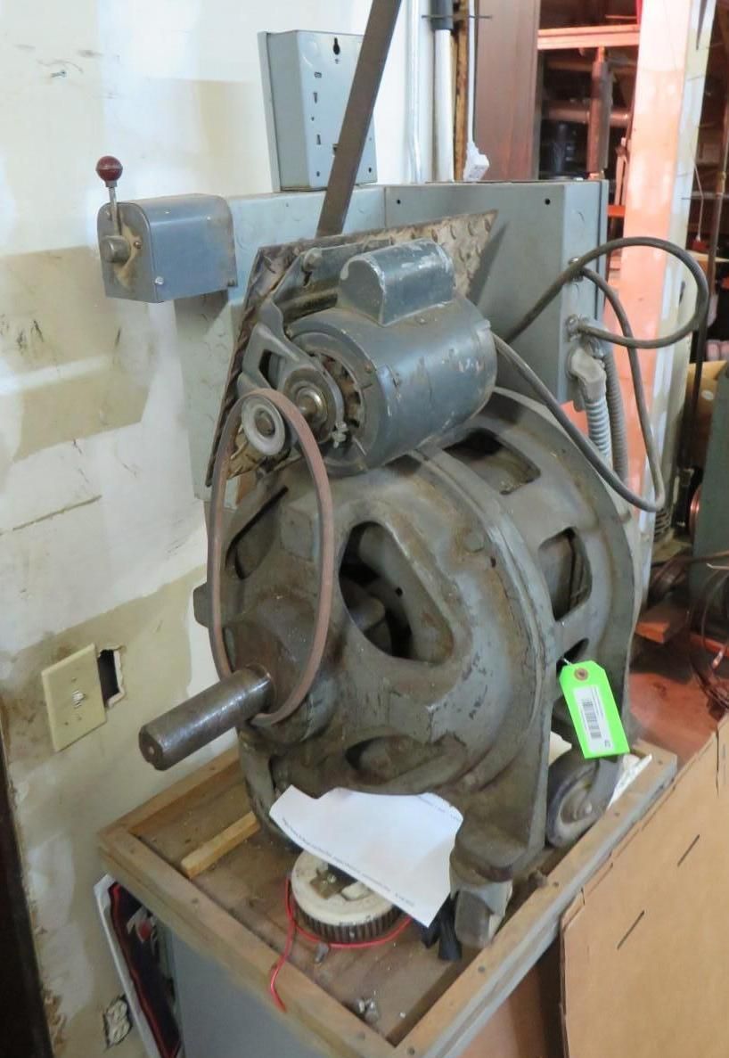 Vintage metalworking machine with motor, belt, and control box on a wooden stand.