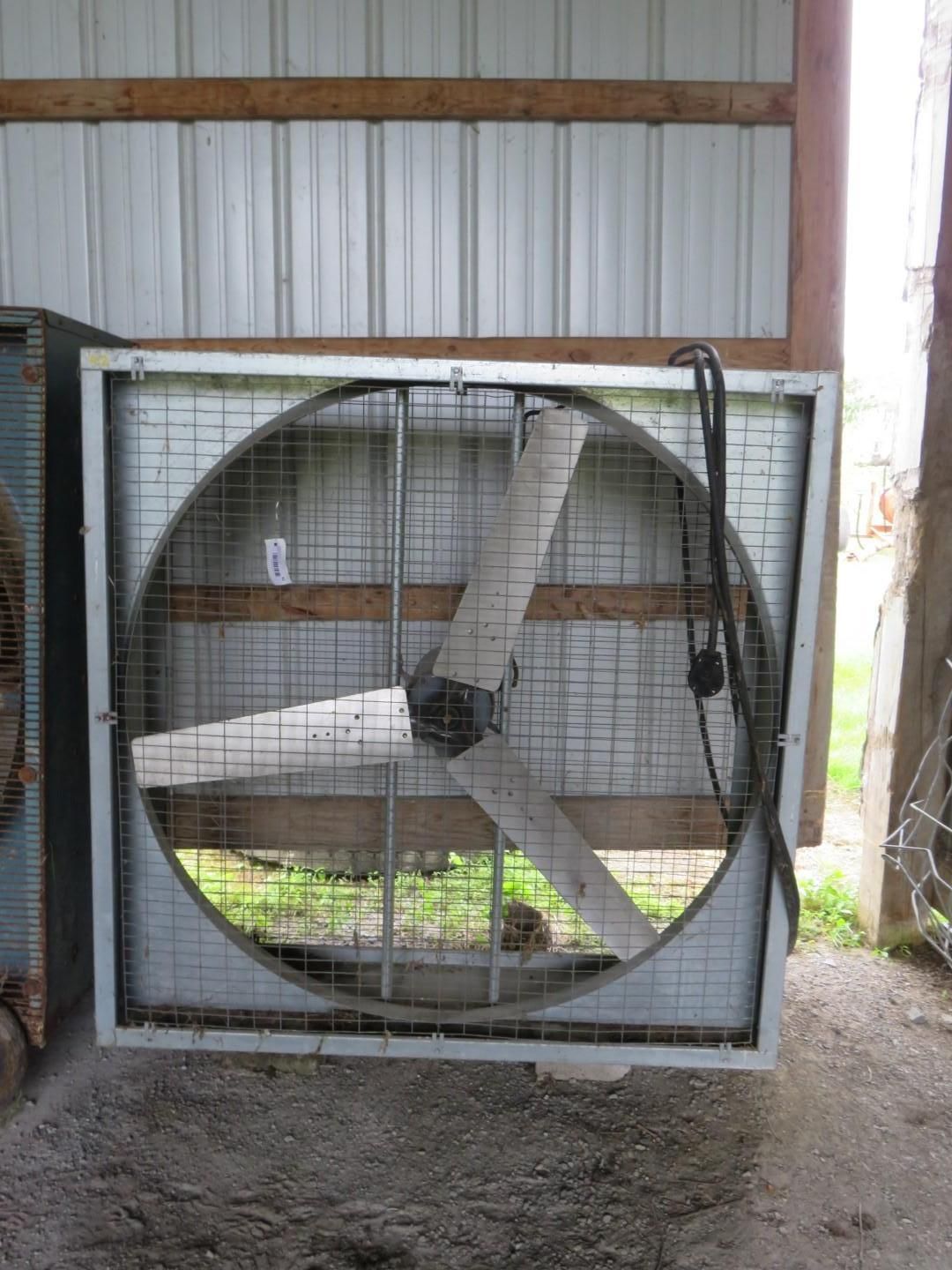 Large square industrial fan with three blades and protective cage.