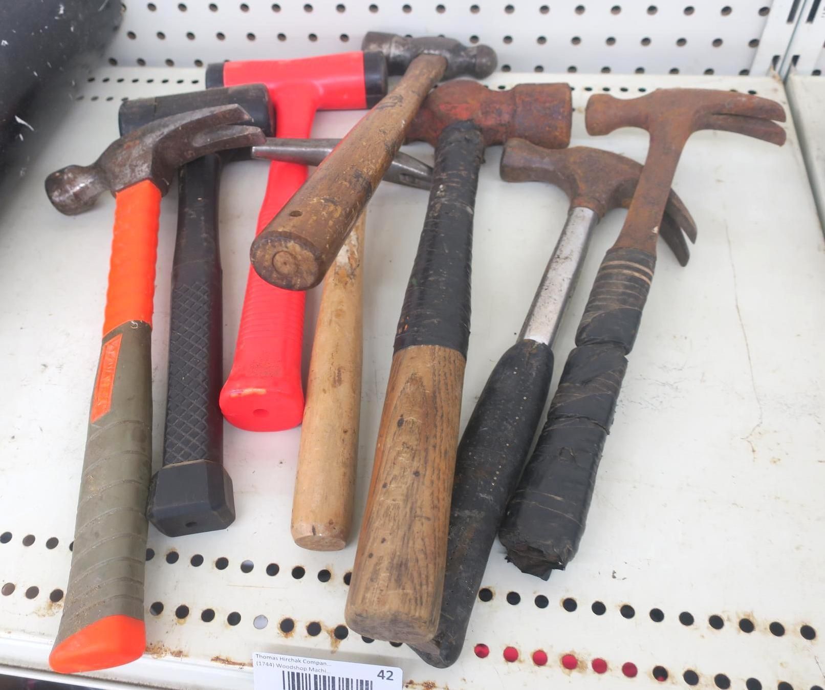 Assorted hammers with wooden and black handles arranged on a store shelf