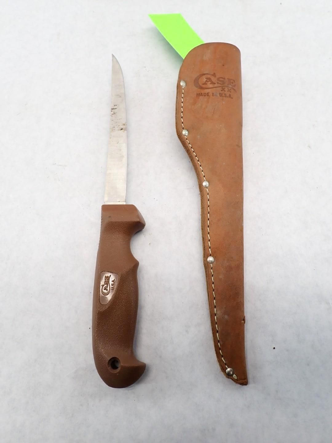 A brown knife with a brown handle and sheath. The sheath is leather. A green price tag is attached.