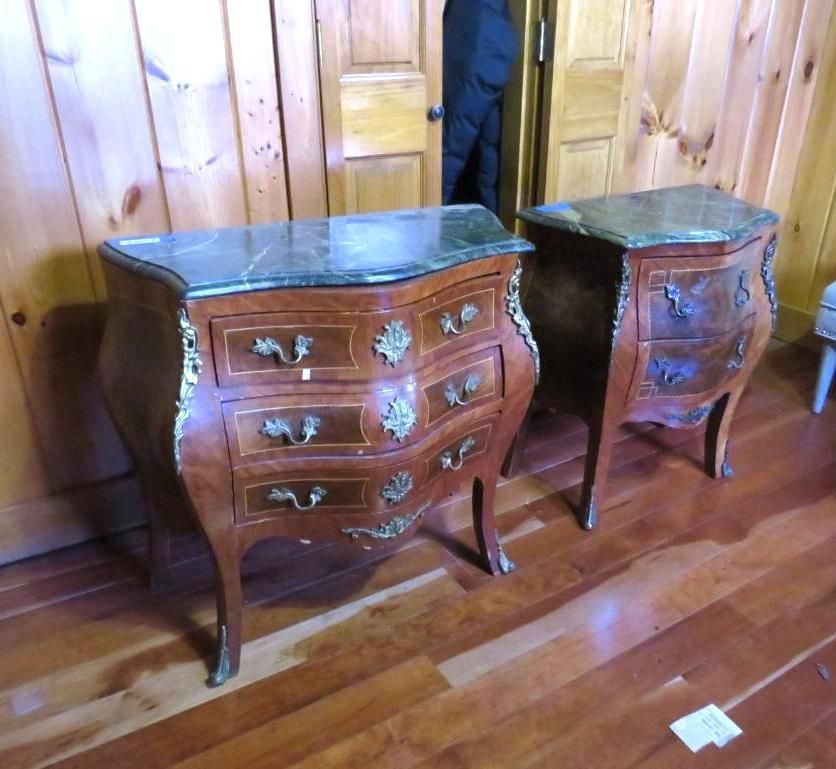 Two ornate wooden side tables with green marble tops, set on a wood floor.