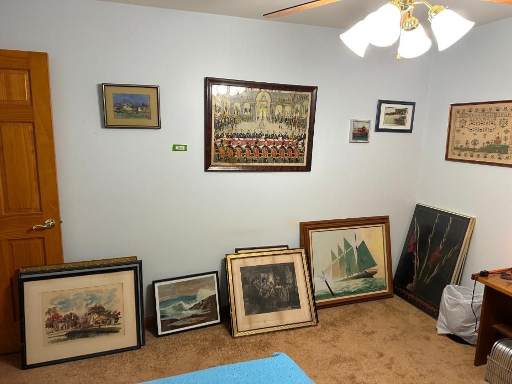 Room with artwork displayed on the walls and leaning on the floor.