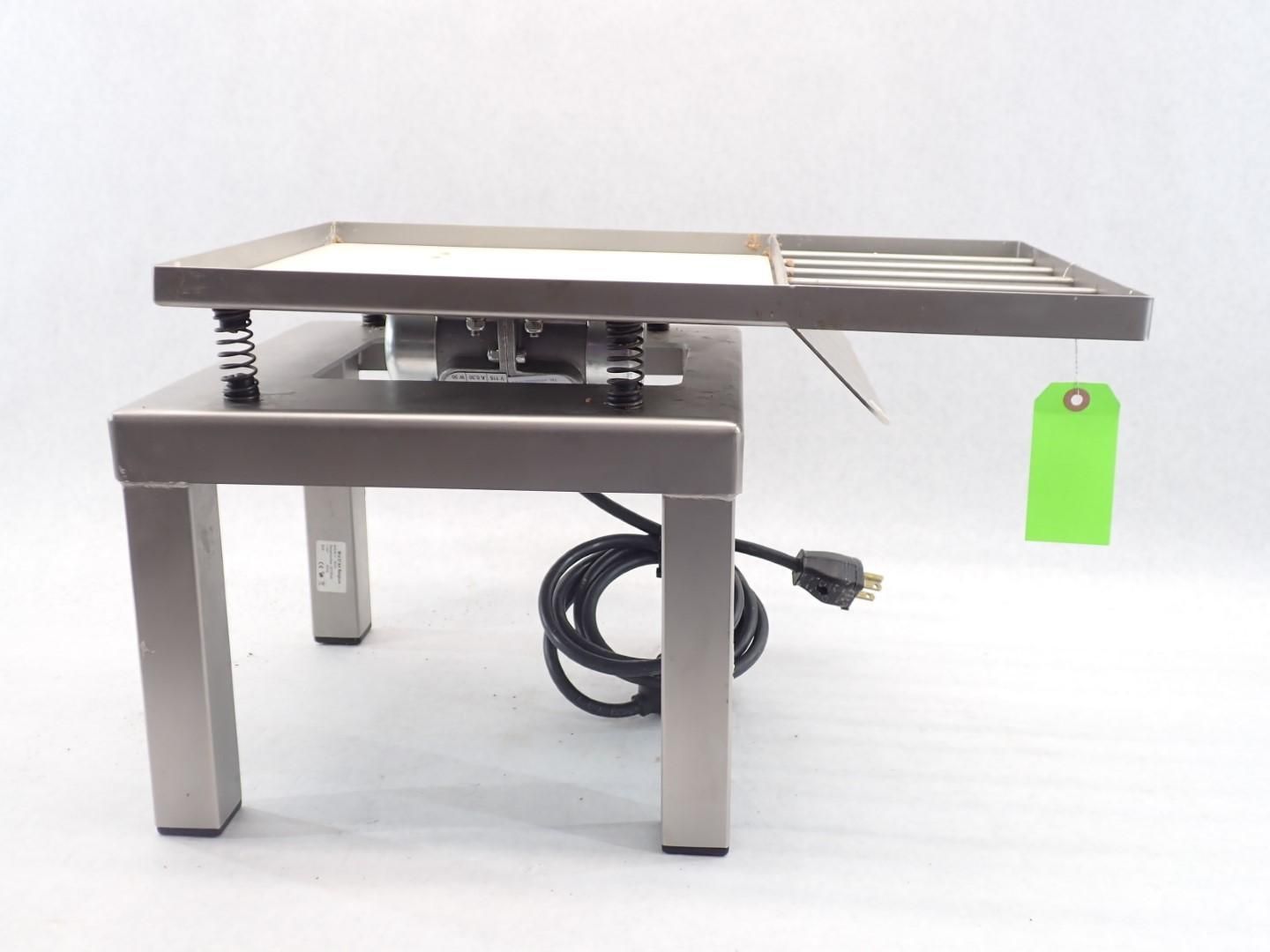 Stainless steel food warmer, elevated on square legs, with a power cord and attached green tag.