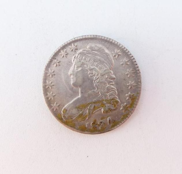 Silver coin with a bust of a woman encircled by stars.