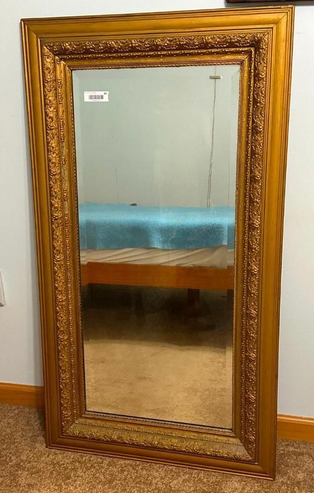 Ornate, gold-framed full-length mirror.