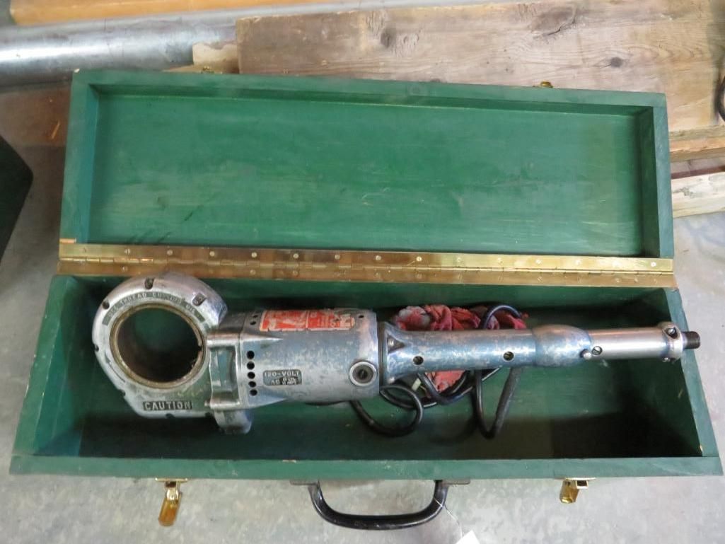 Metal pipe cutting tool in a green wooden case.