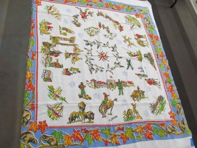 White cloth with colorful Canadian themed illustrations and a blue maple leaf border.