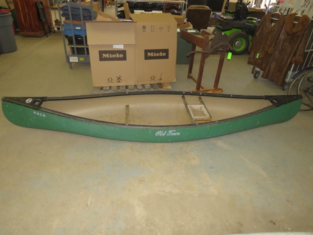 Green Old Town canoe on a concrete floor.