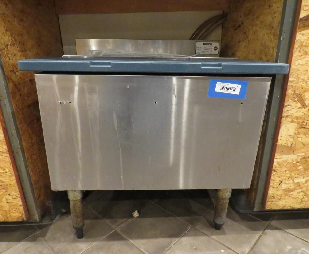 Stainless steel restaurant cooler with blue top, set within a wood-paneled space.