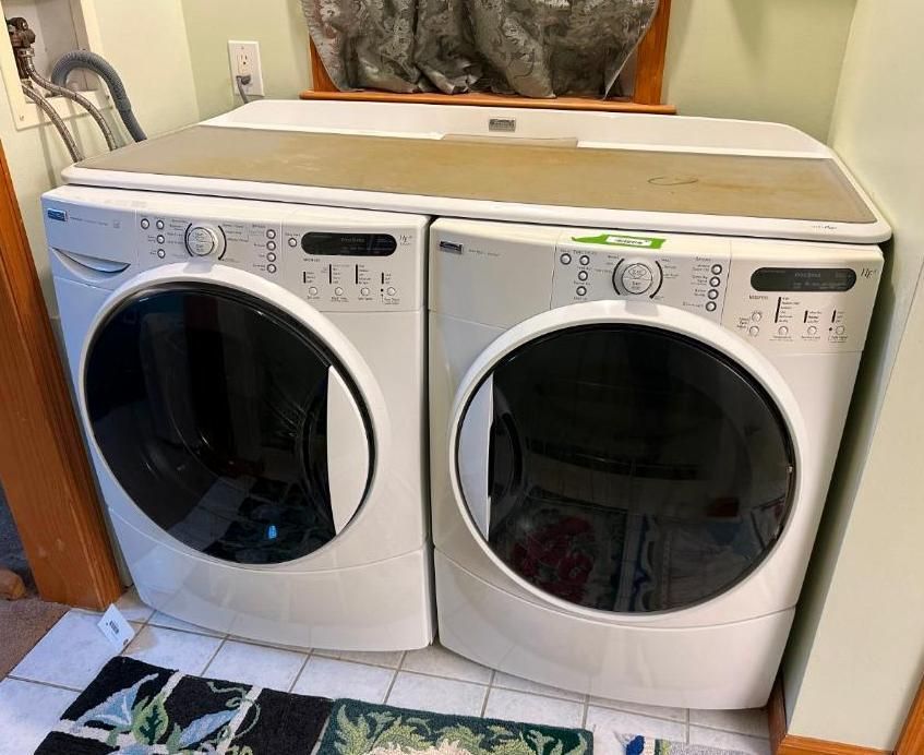 White washer and dryer set with large black doors, placed side by side.