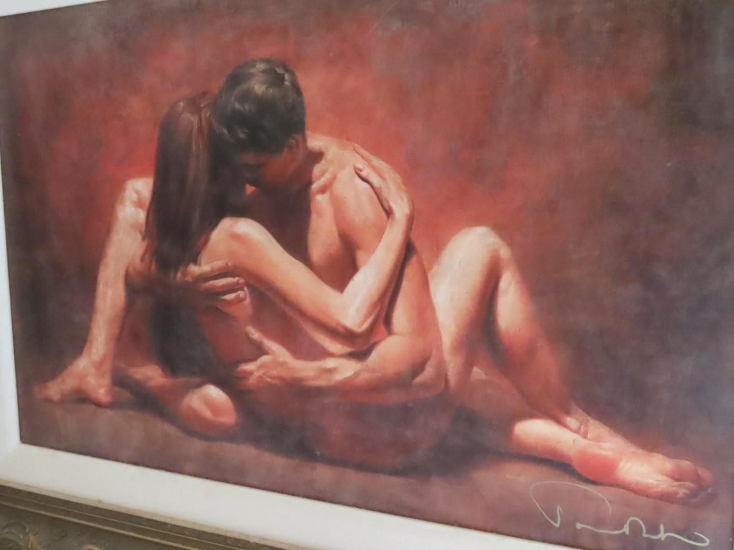 Man and woman embracing intimately, skin tones, red background.