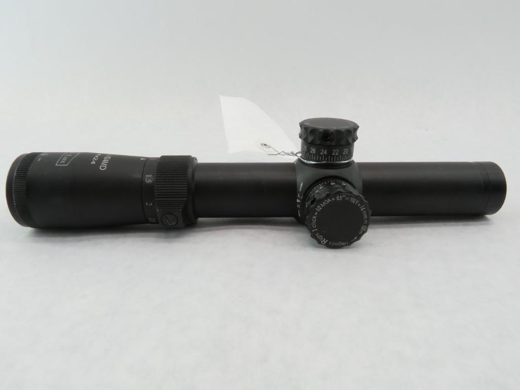 Black rifle scope on a white background. It has adjustable turrets and magnification.