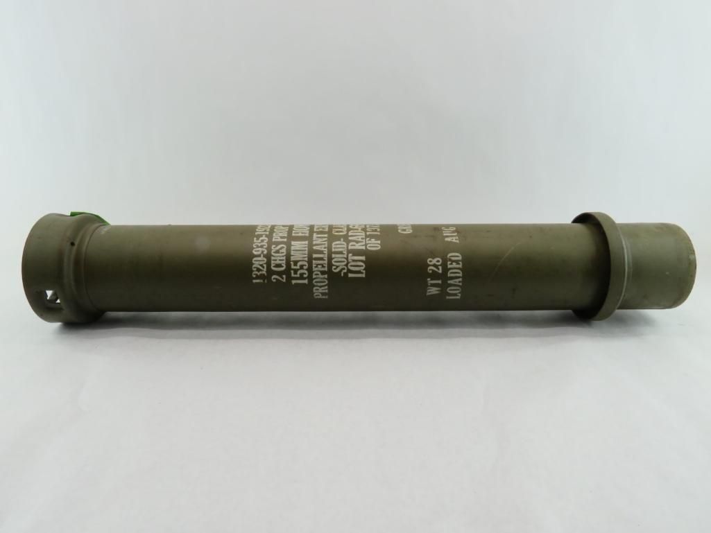 Green cylindrical military smoke grenade with markings.