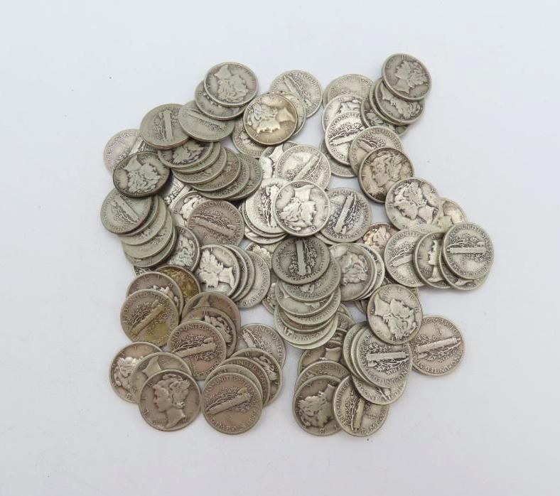 Pile of silver dimes on a white surface, with visible details on the coin's surfaces.