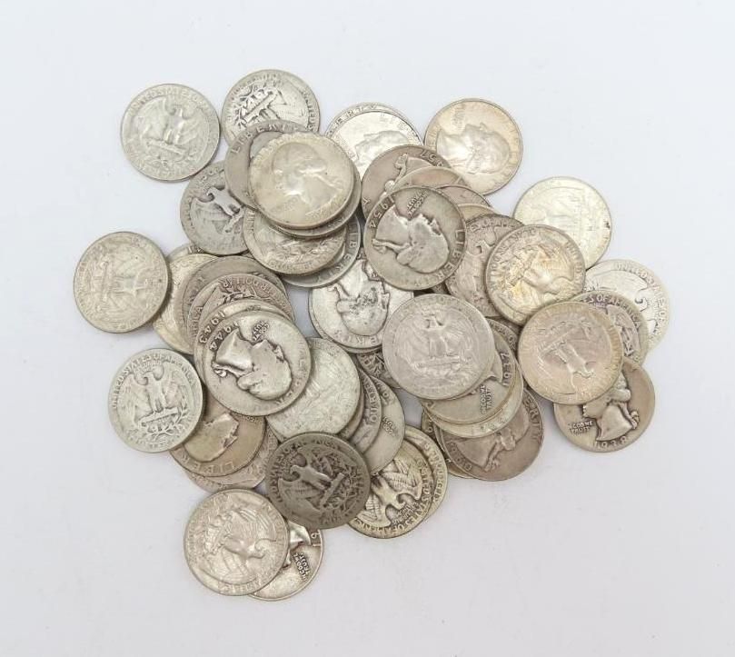 Pile of silver coins, mostly quarters, scattered on a white surface.