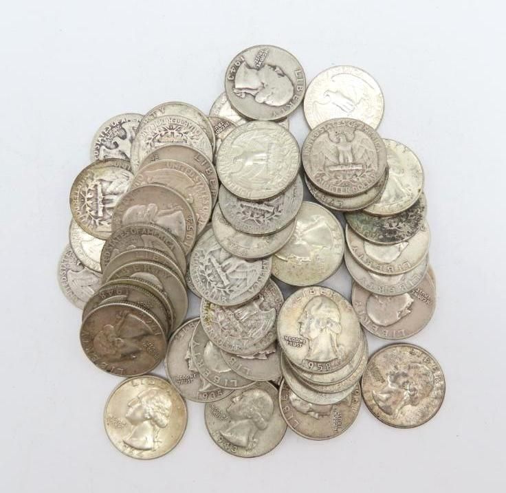 Pile of silver US quarters on a white background.