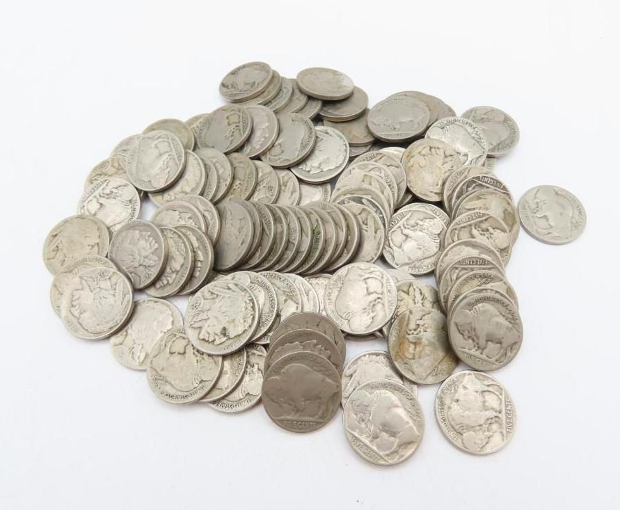 Pile of old Buffalo nickels on a white surface.