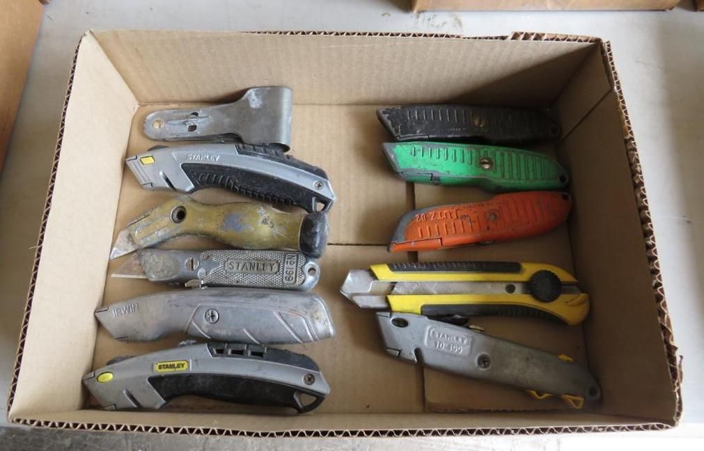 Box of utility knives in various colors, arranged inside.