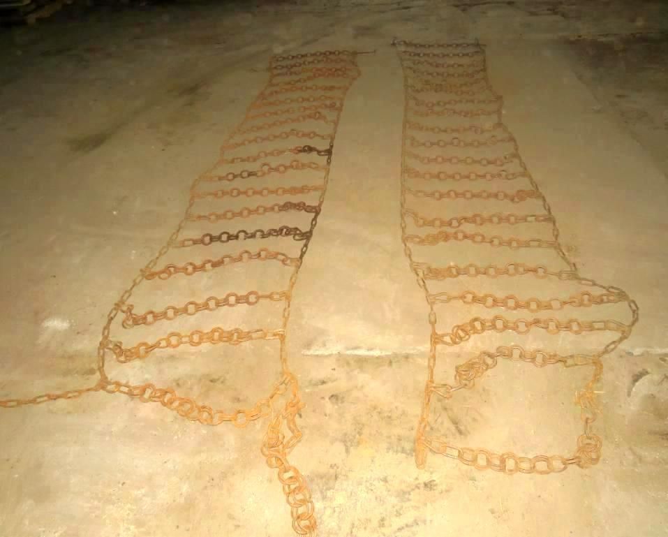 Two lines of chains on a concrete floor.