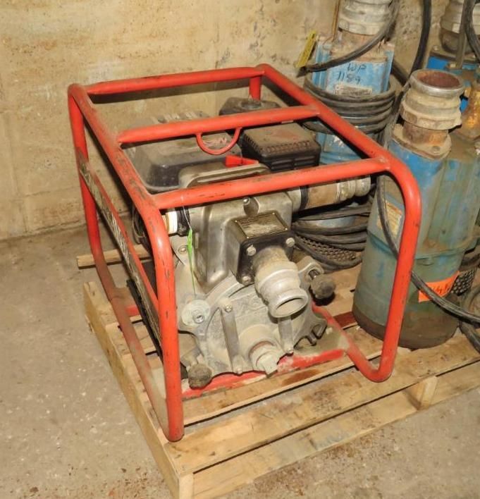 Red-framed water pump on a wooden pallet.