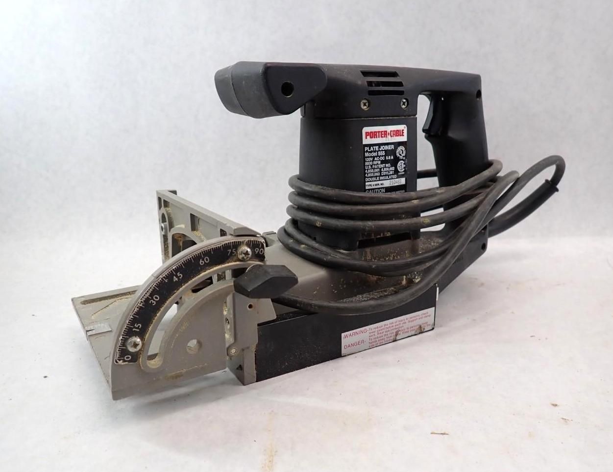 Black power tool with angled guide and cord against a white background.