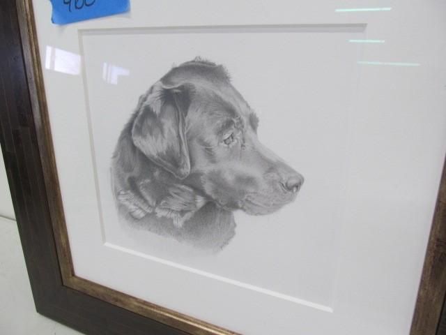 Pencil drawing of a black Labrador dog in profile, framed and matted, brown frame, set against white wall.