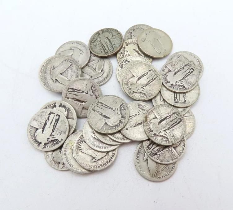 Pile of old silver nickels with a design of a bison on them, on a white surface.